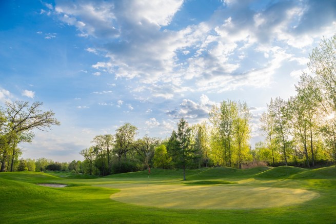 View of golf course with clouds in the sky